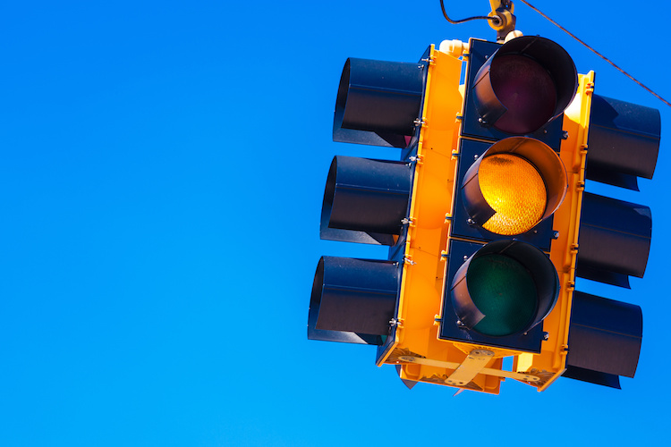 A yellow traffic signal with a sky blue background
